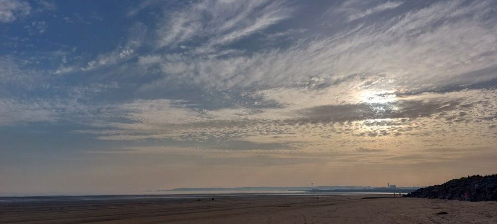 A beach and cloudy sky at dusk